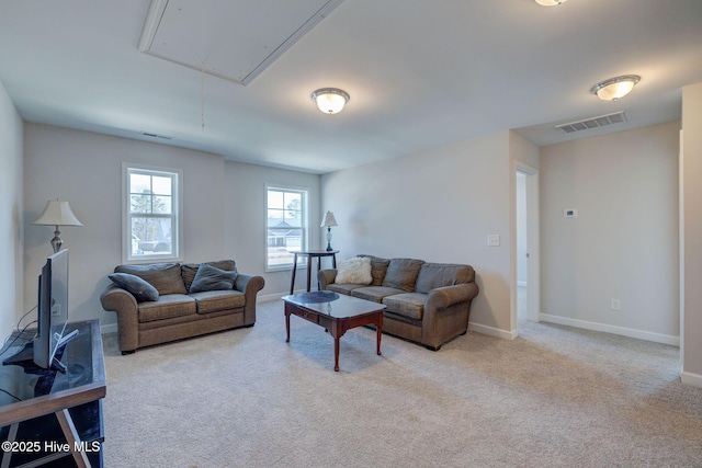 living room with carpet flooring, visible vents, attic access, and baseboards