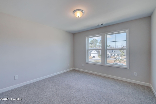 carpeted empty room featuring visible vents and baseboards