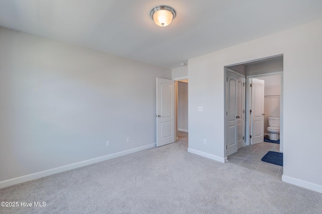 unfurnished bedroom featuring baseboards, carpet floors, and connected bathroom