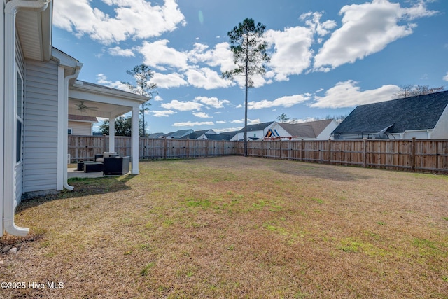 view of yard with a residential view, ceiling fan, and a fenced backyard