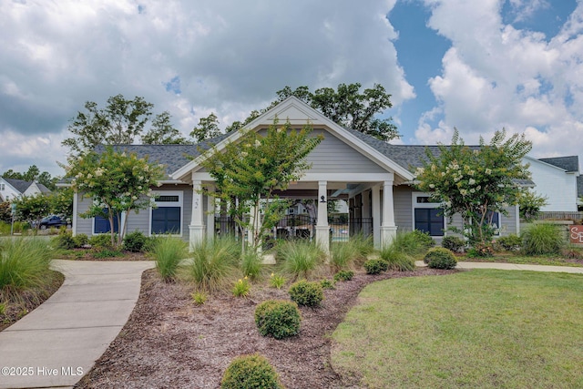 view of front of house with a front yard and a shingled roof