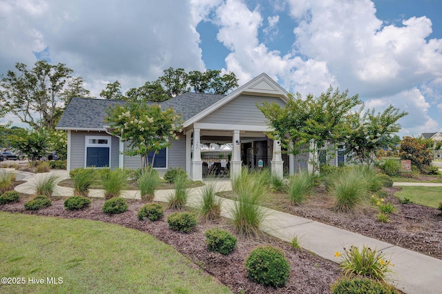 view of front facade featuring a front lawn and roof with shingles