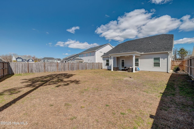 back of property with a yard and a fenced backyard