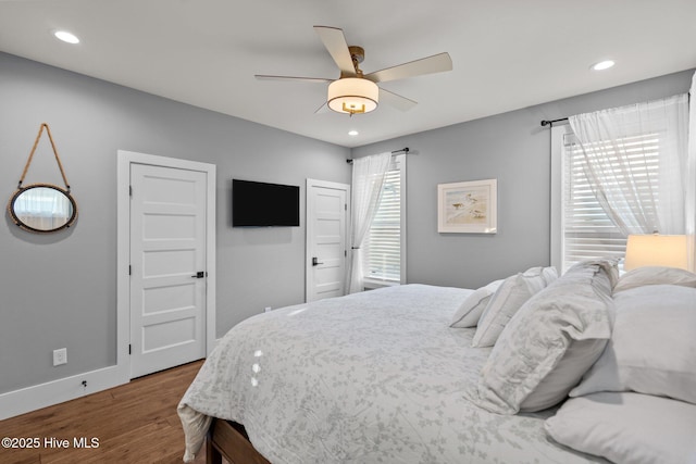 bedroom featuring recessed lighting, baseboards, multiple windows, and wood finished floors