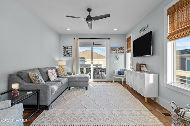 living room featuring visible vents, baseboards, recessed lighting, wood finished floors, and a ceiling fan