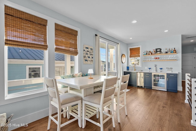 dining room featuring wet bar, wine cooler, recessed lighting, and wood finished floors