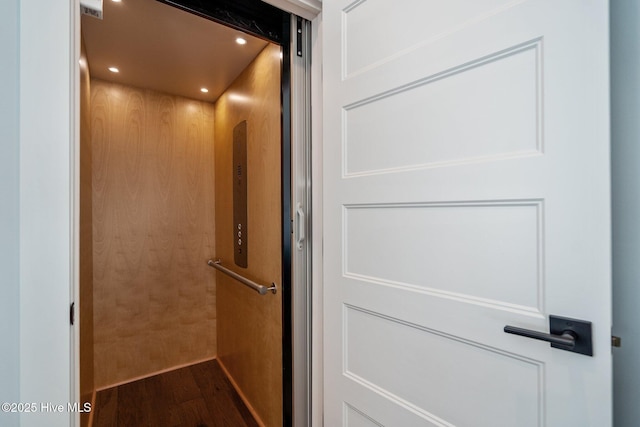 interior details with elevator, recessed lighting, and wood finished floors