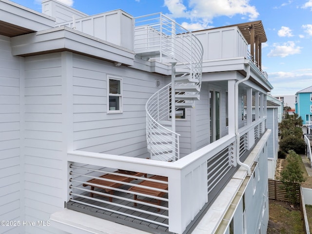 view of side of property featuring stairway and fence