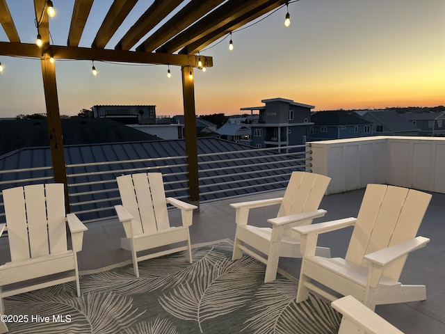 patio terrace at dusk featuring a residential view, a balcony, and a pergola