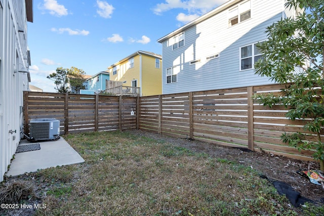 view of yard featuring a patio, central AC unit, and a fenced backyard