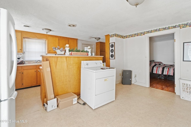 laundry room with washer / dryer, laundry area, visible vents, a textured ceiling, and light floors