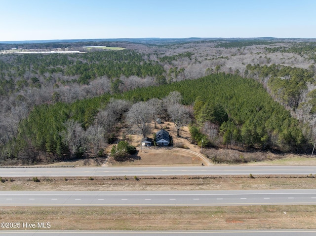 bird's eye view with a wooded view