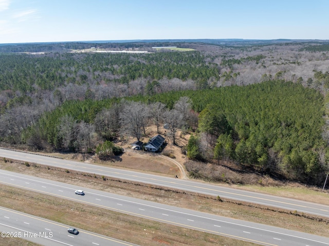 bird's eye view with a wooded view