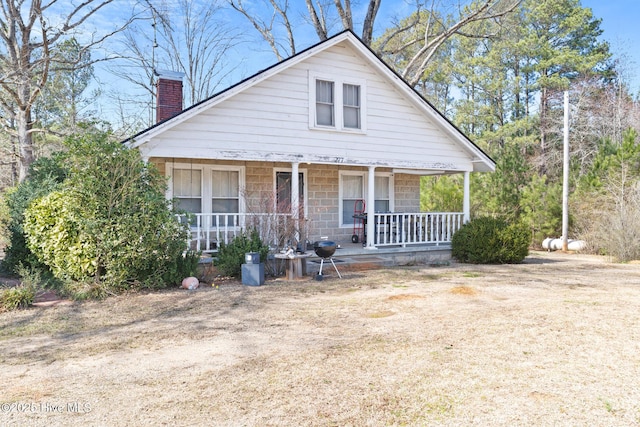 bungalow-style home featuring a chimney and a porch