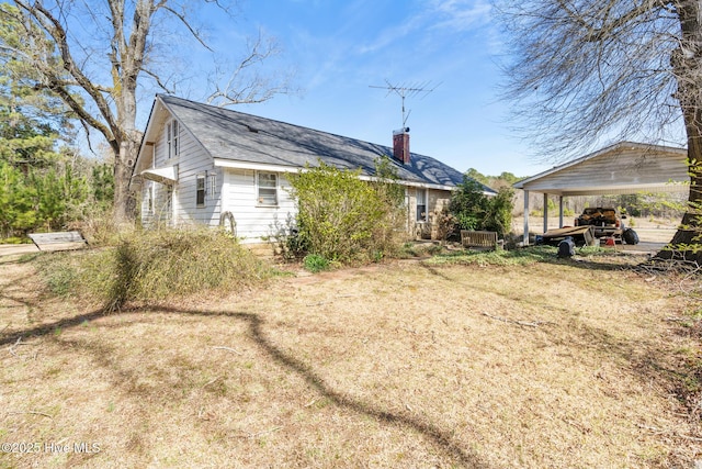 rear view of house with dirt driveway and a chimney