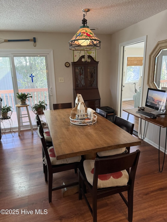 dining area with baseboards, dark wood finished floors, and a textured ceiling