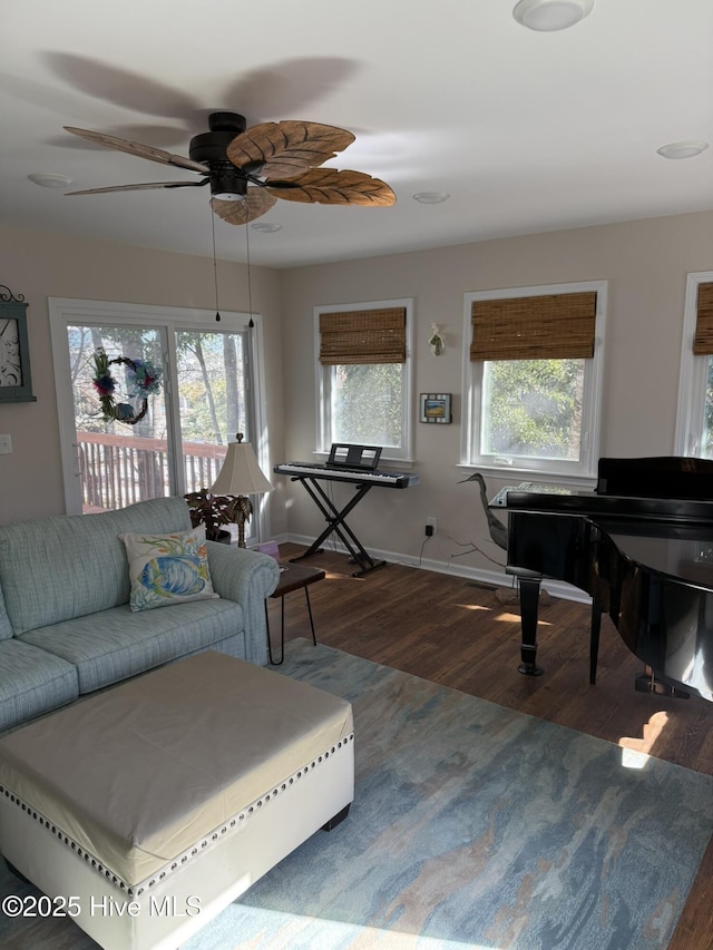 living area featuring a wealth of natural light, baseboards, and wood finished floors