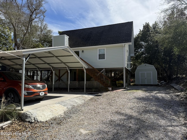 view of front of house with an outdoor structure, a storage unit, roof with shingles, and a chimney