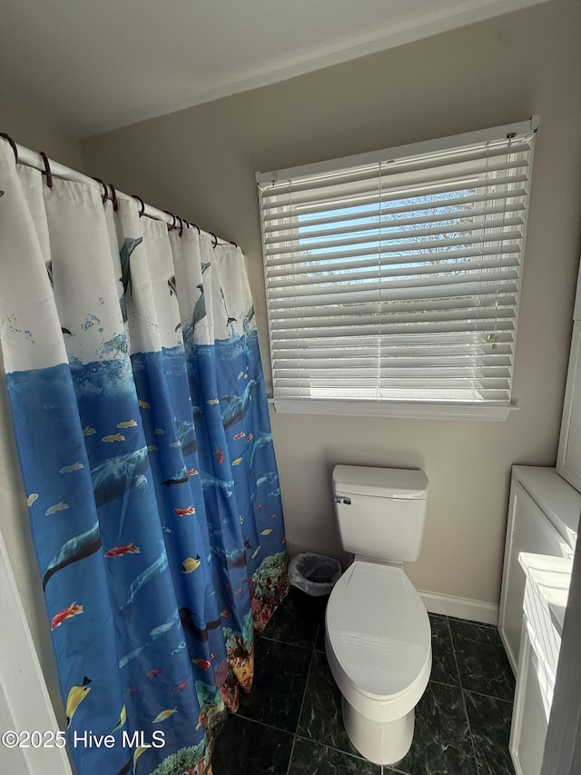 full bath with marble finish floor, a shower with curtain, toilet, and baseboards