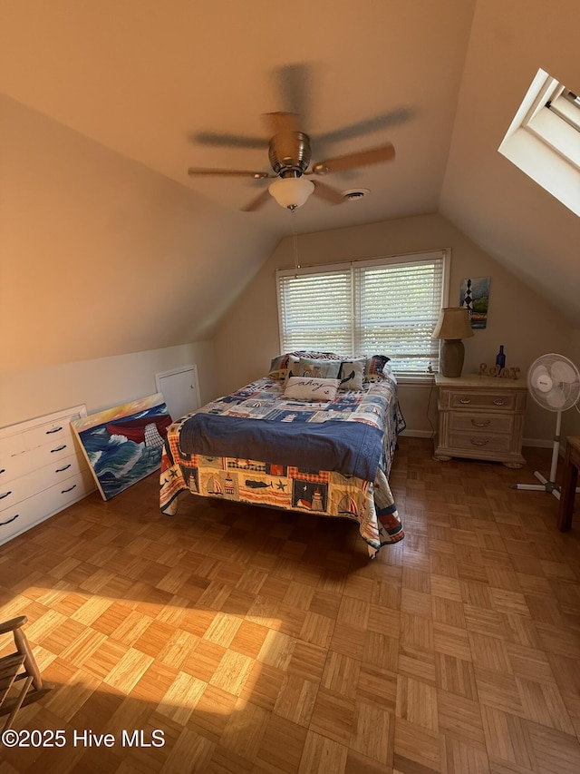 bedroom with lofted ceiling with skylight and ceiling fan