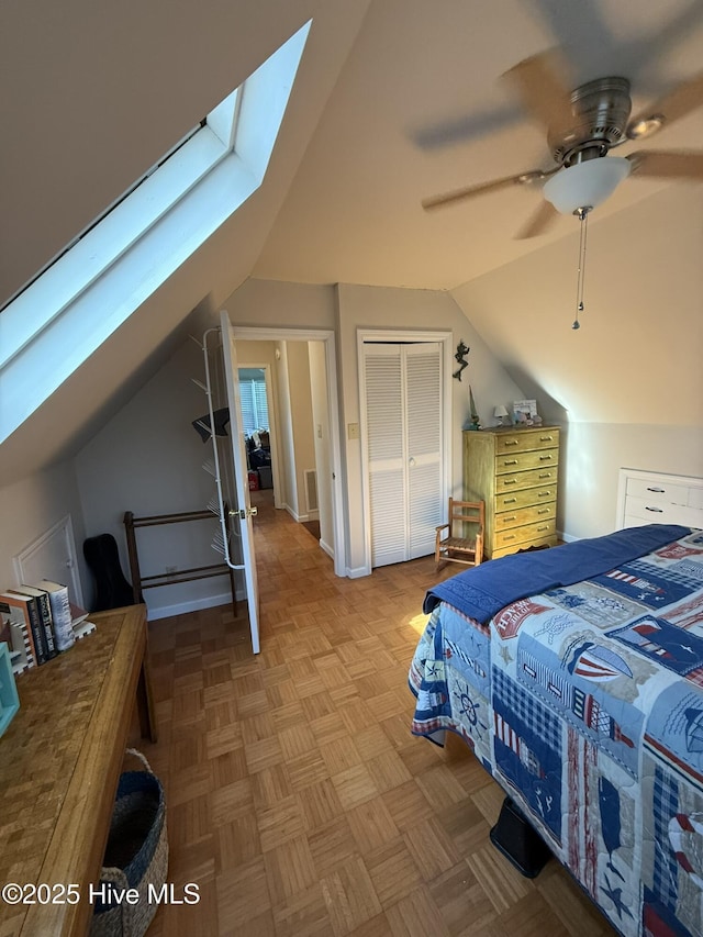 bedroom featuring vaulted ceiling with skylight, ceiling fan, and a closet