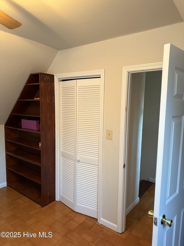 unfurnished bedroom with baseboards, vaulted ceiling, and a closet