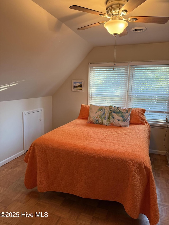 bedroom featuring lofted ceiling, visible vents, a ceiling fan, and baseboards