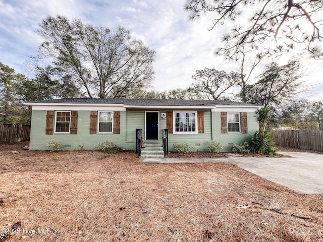 ranch-style home featuring crawl space, brick siding, and fence