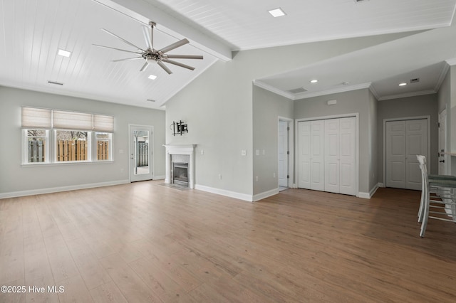 unfurnished living room featuring vaulted ceiling with beams, light wood finished floors, a fireplace, and baseboards