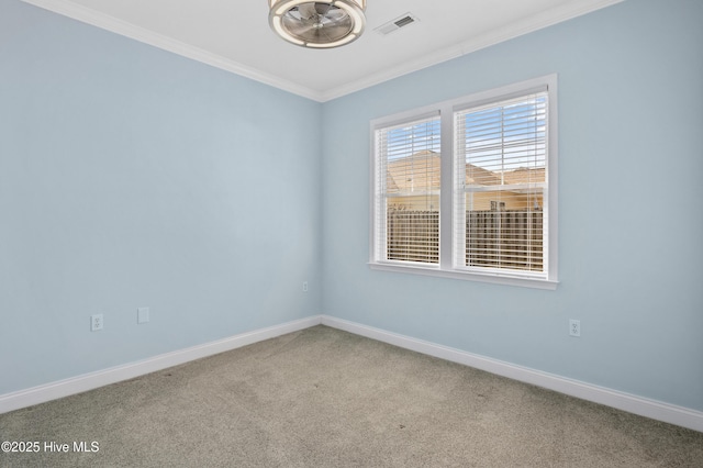 carpeted empty room featuring ornamental molding, visible vents, and baseboards