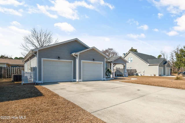 ranch-style house with a garage, concrete driveway, fence, and central air condition unit