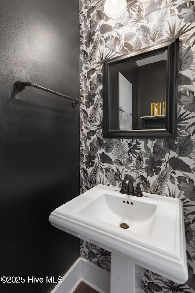 bathroom featuring wallpapered walls and a sink