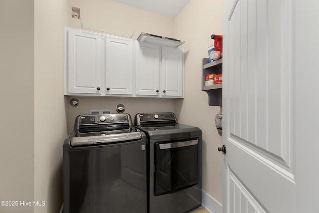 washroom featuring baseboards, cabinet space, and washer and dryer