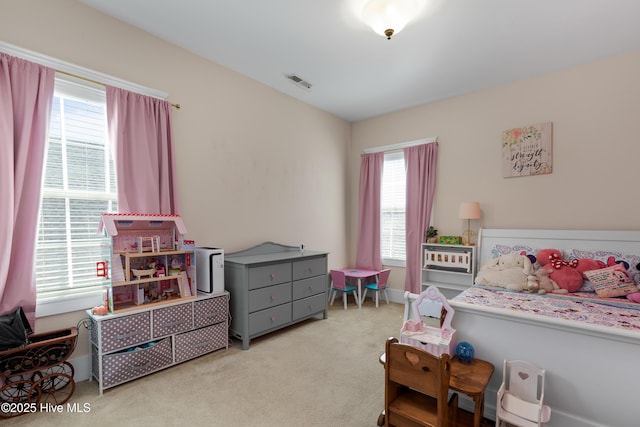 bedroom featuring carpet, visible vents, and multiple windows