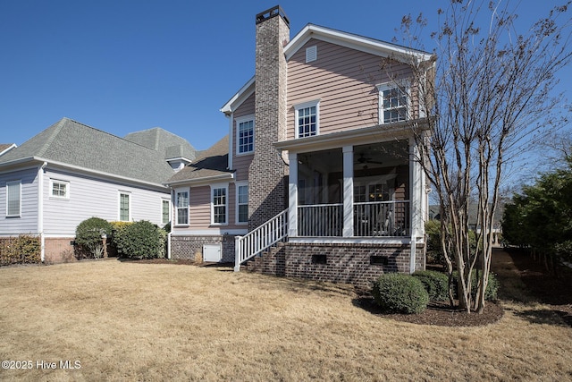 exterior space featuring a yard, a chimney, a ceiling fan, a sunroom, and crawl space