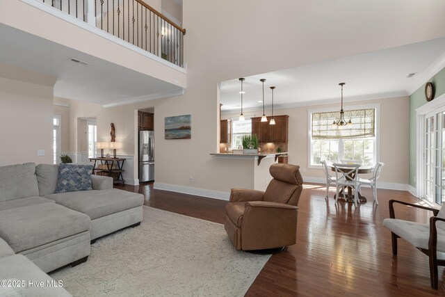 312 Moss Tree Dr, Wilmington, NC 28405 - living area with baseboards, visible vents, ornamental molding, and dark wood-type flooring