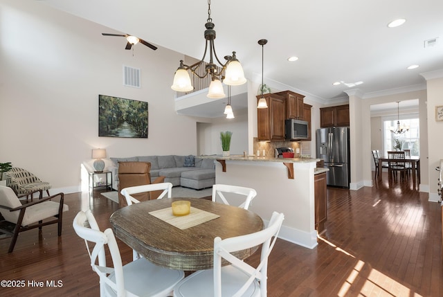 dining area featuring ornamental molding, dark wood-style flooring, visible vents, and baseboards