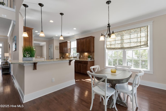 dining area featuring dark wood-style floors, ornamental molding, recessed lighting, and baseboards