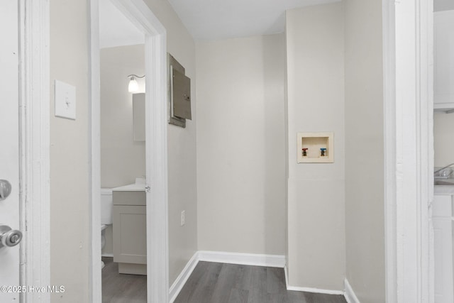 washroom with baseboards and dark wood-style flooring