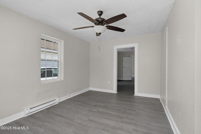 spare room with a textured ceiling, baseboards, baseboard heating, and dark wood-type flooring