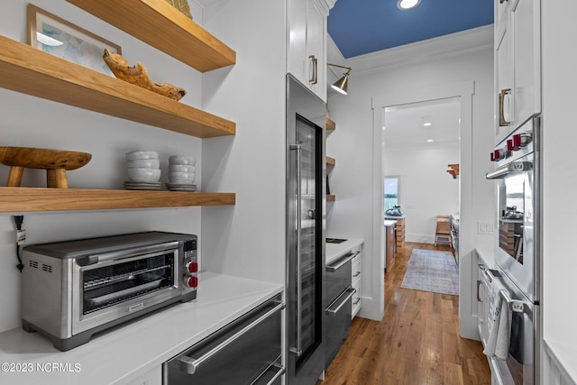 kitchen featuring open shelves, light countertops, oven, and white cabinets