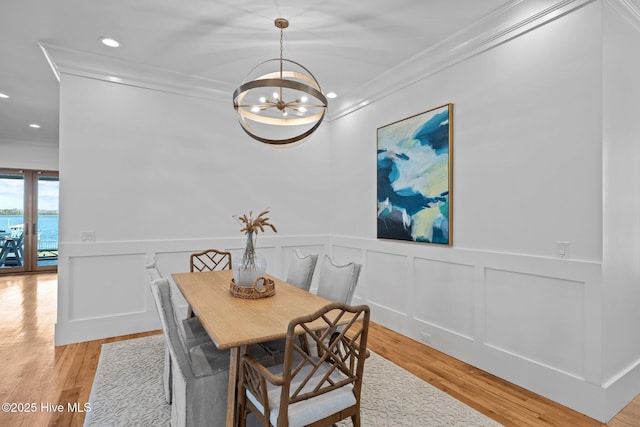 dining space featuring a notable chandelier, recessed lighting, ornamental molding, light wood-style floors, and wainscoting