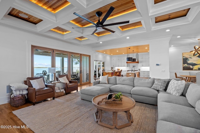 living room with beamed ceiling, coffered ceiling, and wood finished floors