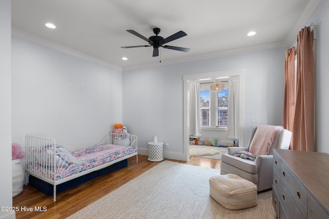 bedroom with crown molding, baseboards, wood finished floors, and recessed lighting