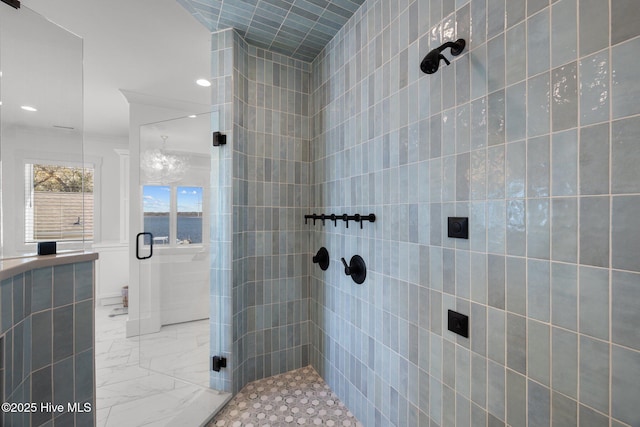 bathroom featuring marble finish floor, a stall shower, and tile walls