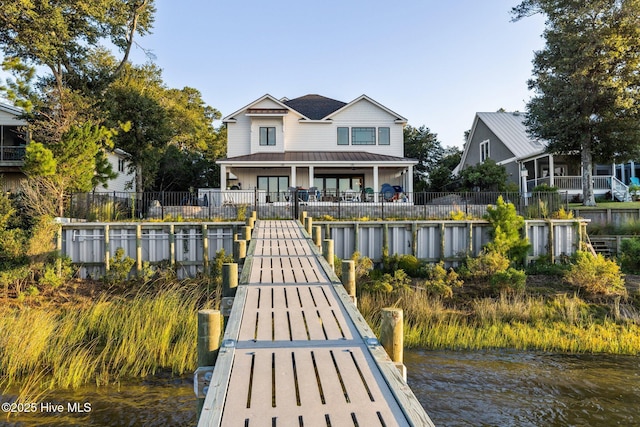 view of dock featuring a water view and fence