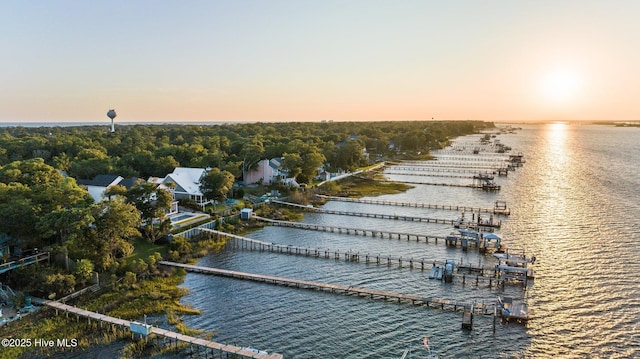 aerial view at dusk featuring a water view