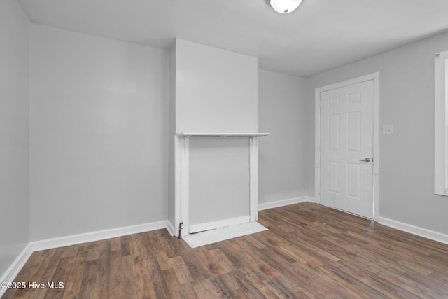 unfurnished living room with baseboards and wood finished floors