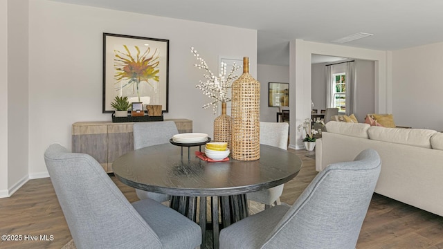 dining space featuring visible vents, baseboards, and wood finished floors