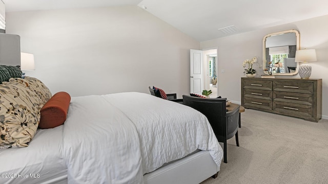 bedroom with lofted ceiling, visible vents, and light colored carpet